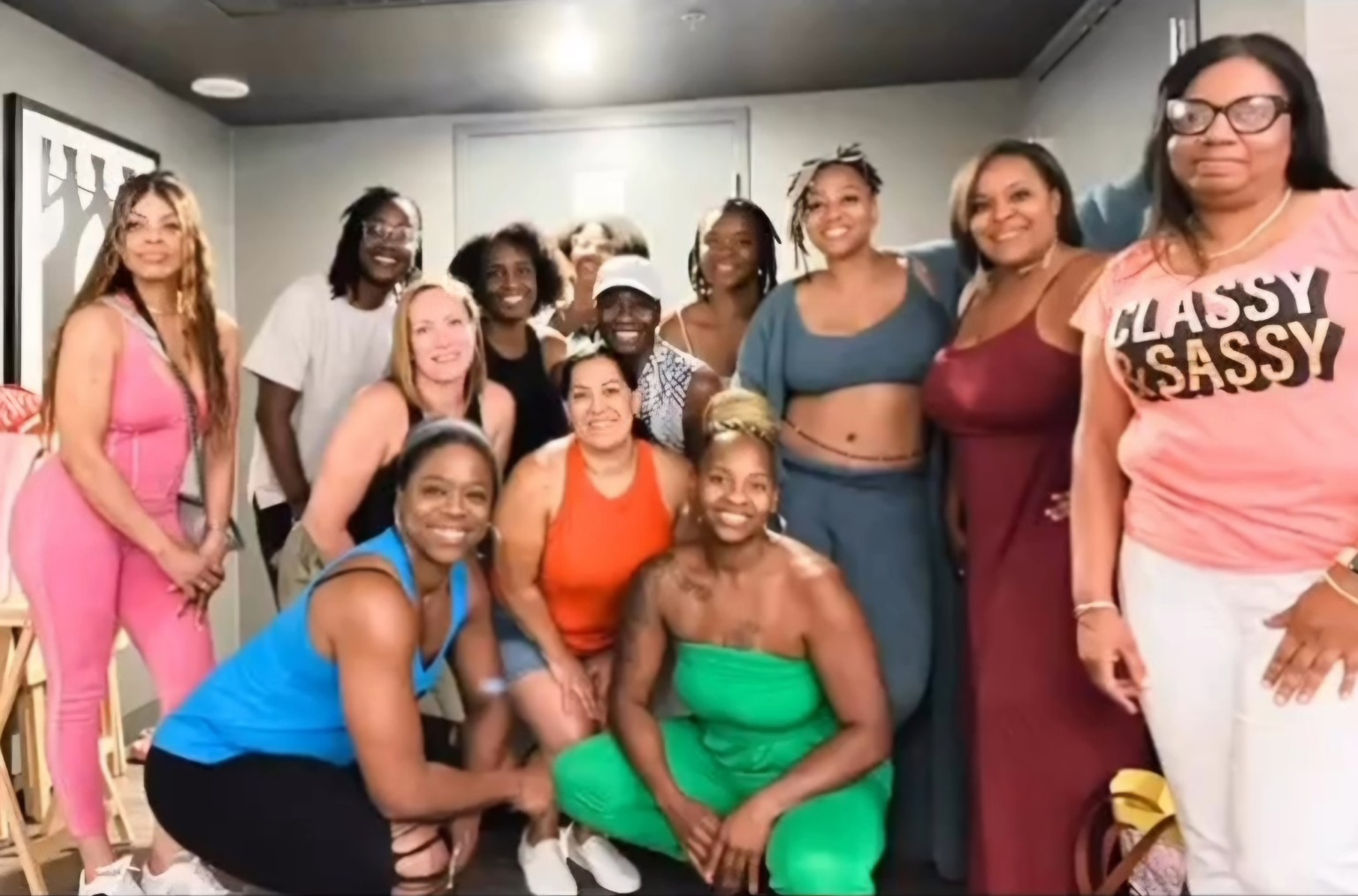 Women smiling together for a group photograph indoors